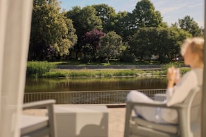 A view of a park with a pond, trees, and a fence. - Persante Sunrise Collection Marina & River by Downtown Apartments (Kołobrzeg)