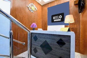 Una recepción de hotel con un letrero que dice 'HOTEL', un reloj decorativo y una lámpara.