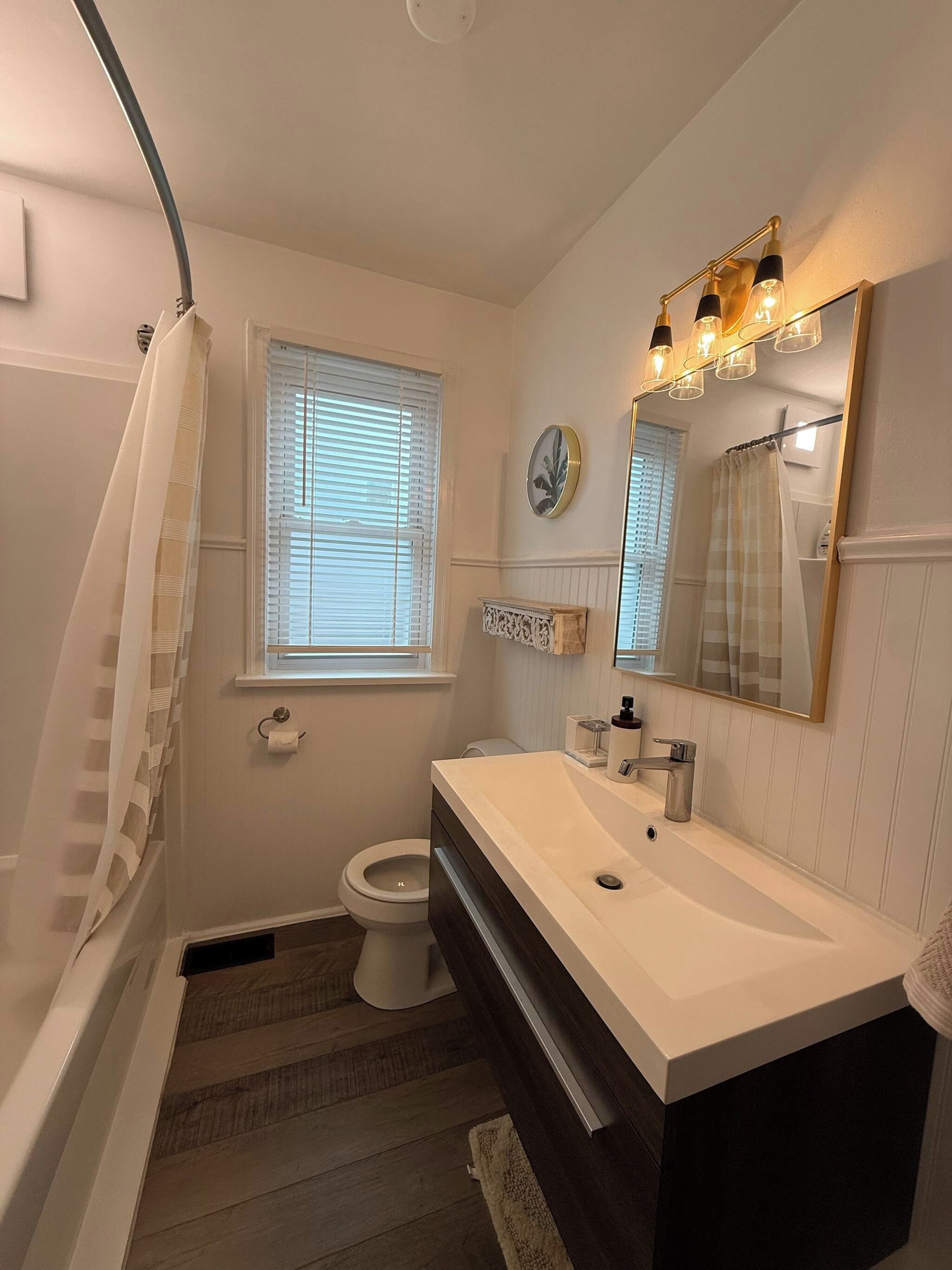 A bathroom with a bathtub, toilet, and sink.