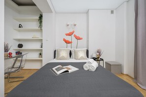 A modern bedroom with a bed, a side table, a chair, and a bookshelf. - Lumina Comfy 2BR Apart near the Center of Warsaw (Warszawa)