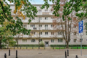 A multi-story residential building with a parking sign indicating available parking. - Lumina Comfy 2BR Apart near the Center of Warsaw (Warszawa)