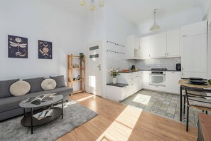 Een modern appartement met een woonkamer, kitchenette en eethoek.