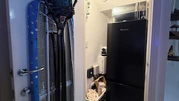 A compact kitchen with a refrigerator, a microwave, and a small countertop.