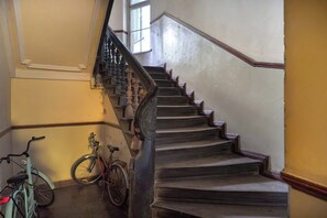 Eine Treppe mit Handlauf und ein Fahrrad, das an der Wand lehnt.