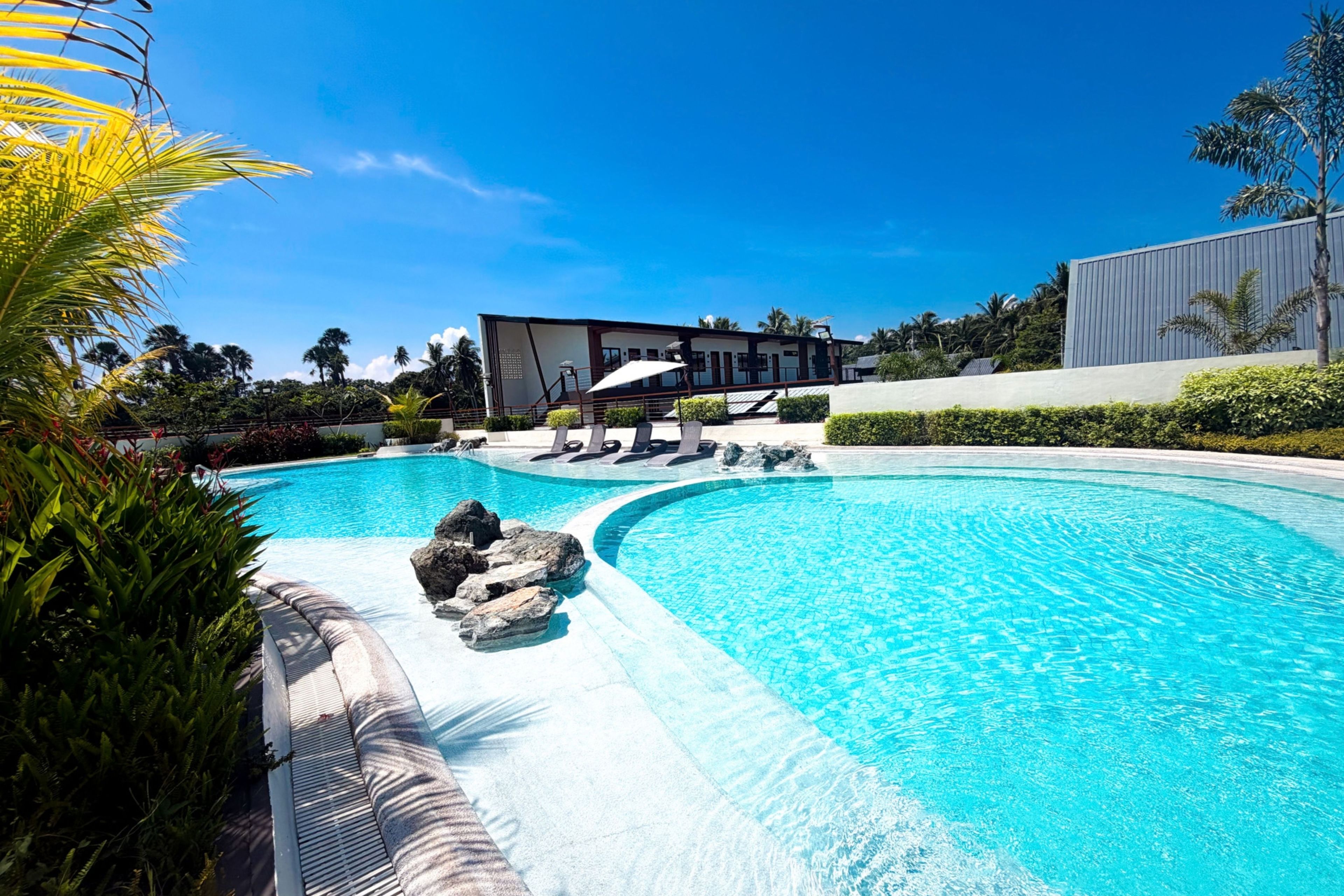 Una piscina con un edificio moderno al fondo.