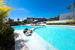 Una piscina con un edificio moderno al fondo.