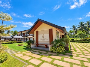 A resort with a prominent entrance, a well-maintained lawn, and a clear sky.