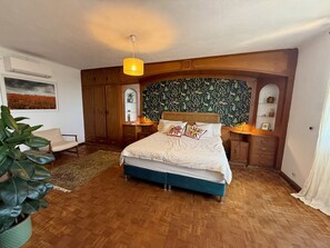Ein Schlafzimmer mit einem großen Bett, einem Holzschrank und einer Wandverzierung.