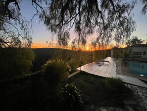 A pool area with a tiled deck, surrounded by vegetation and a stone wall. - Secluded Mountainside Retreat w/ Pool, Sauna + Gym (Caldas de Monchique)