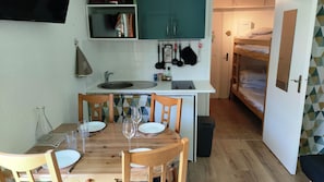 A compact kitchen with a dining table set for two, a sink, and a small countertop. - Studio with balcony and ski slopes view (Les Deux Alpes)
