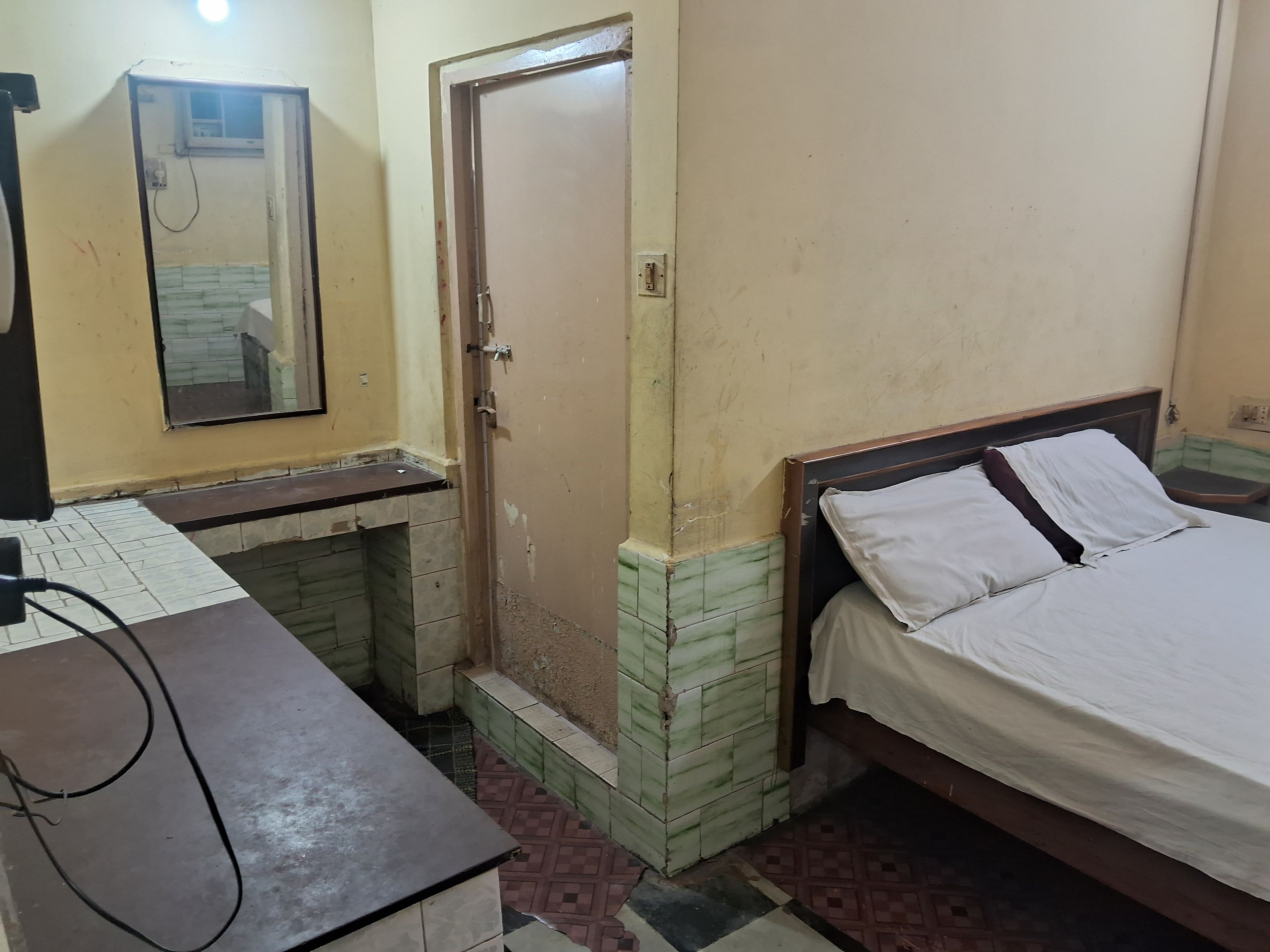 Una habitación con cama, escritorio y puerta.