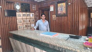 A reception desk with a clock, framed pictures, and a calendar on the wall.