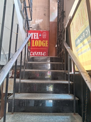 A staircase with a sign for 'TEL LODGE' and a partially visible sign for 'COMPS'. - Hotel Swamy Lodge  (Vijayawada)