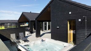 A modern building with a hot tub, outdoor seating, and a covered patio area. - VillaVilla 997 - Odsherred, Nordsjælland (Højby)