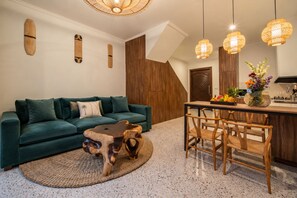 Un espacio moderno para vivir con un sofá verde, una mesa de comedor de madera y una mesa de centro original.