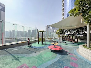 A rooftop playground with exercise equipment, a seating area, and a view of the cityscape. - Stylish 1BR Stay in DAMAC Paramount | Business Bay (Dubai)