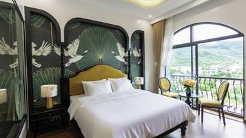 A hotel room with a large bed, a balcony with a view, and a decorative headboard.