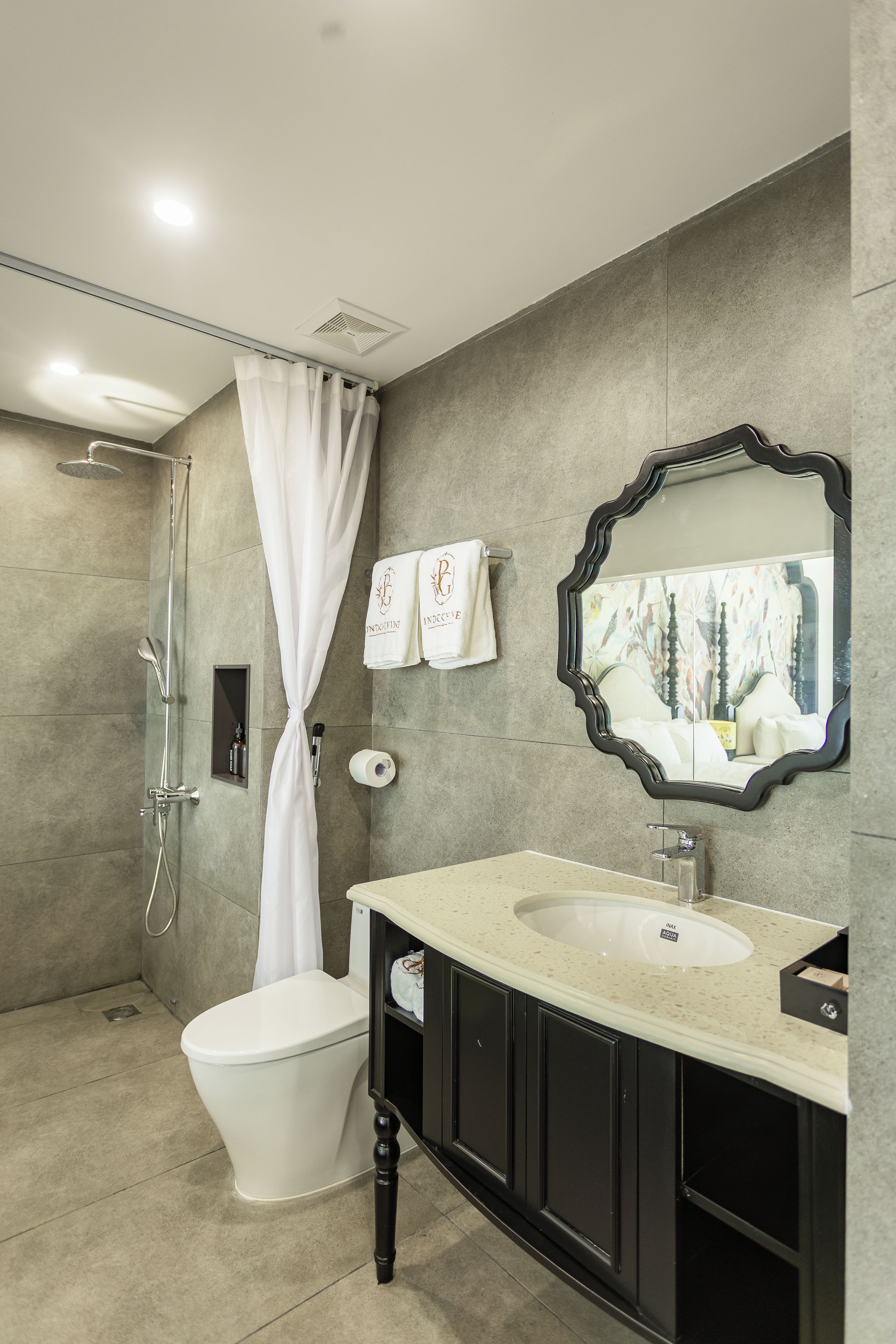 A modern bathroom with a shower, toilet, vanity, and a large mirror.