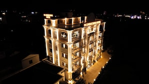 A multi-story hotel with illuminated signage, balconies, and a well-lit entrance.