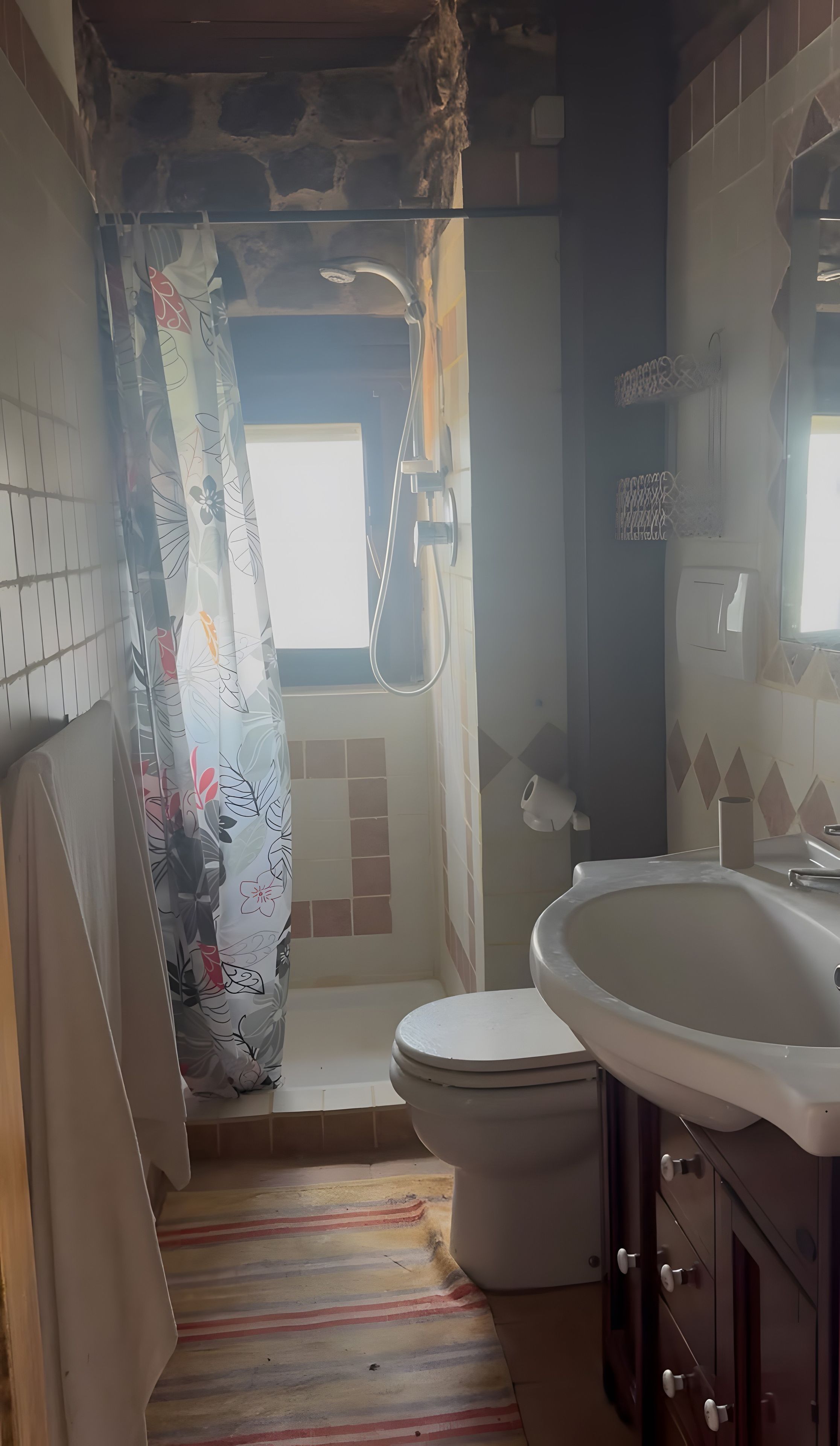 Ein Badezimmer mit Dusche, Toilette und Waschbecken.