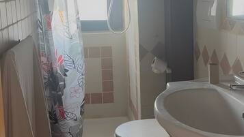 Ein Badezimmer mit Dusche, Toilette und Waschbecken.