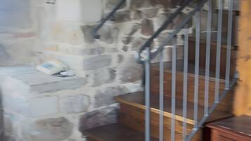 Eine Treppe mit Steinwänden, Holzstufen und Metallgeländern.
