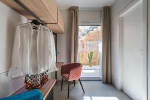 A modern room with a wooden ceiling, a bench, a pink chair, and a view of a cactus through a glass door. - Luxurious villa with outdoor pool, heated indoor pool, wellness area, and outdoor Jacuzzi in Cornino – DiCasaInSicilia (Custonaci)