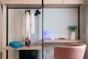 A compact room with a desk, a chair, a small table with a lamp, and a wall-mounted shelf with a plant. - Luxurious villa with outdoor pool, heated indoor pool, wellness area, and outdoor Jacuzzi in Cornino – DiCasaInSicilia (Custonaci)
