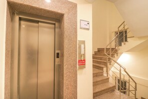 An elevator with a control panel and a sign indicating the lift direction.
