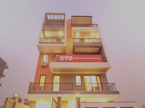 A multi-story hotel with a prominent sign for 'OYO Flagship Hotel Ram Krishna Residency'. - Hotel O Comfort Residency  (Gurugram)