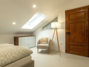 A bedroom with a skylight, a bed, a chair, a floor lamp, and a wardrobe. - Lovely apartment for 2 guests with WIFI, TV and terrace (Acquarossa)