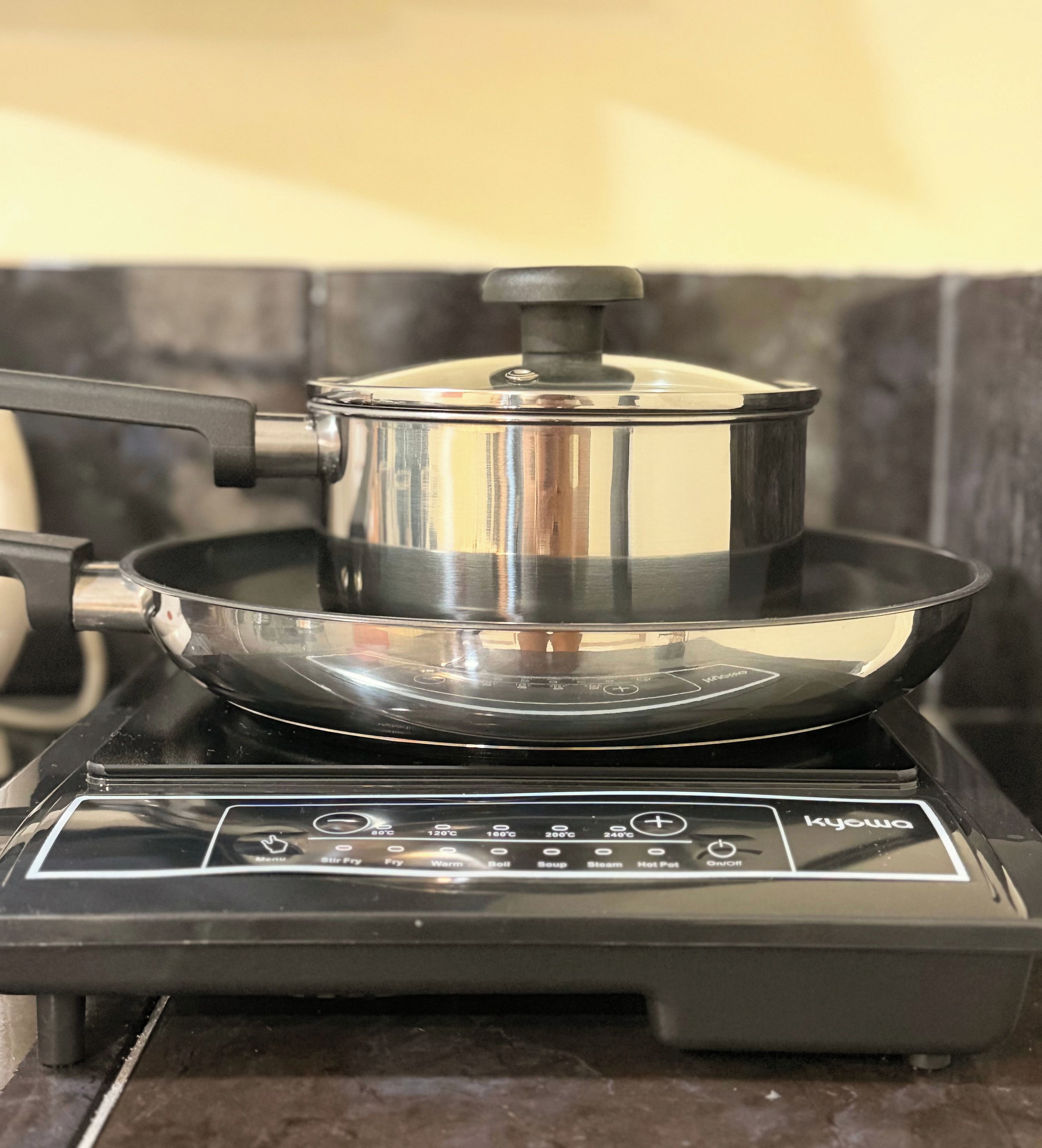 Une cuisine équipée d’une cuisinière, d’une casserole et d’une poêle.