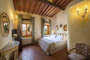 A bedroom with a bed, a vanity with a mirror, and a window with curtains. - Villa Grevigiana 12 pool and SPA - My Rental Homes (Panzano In Chianti)