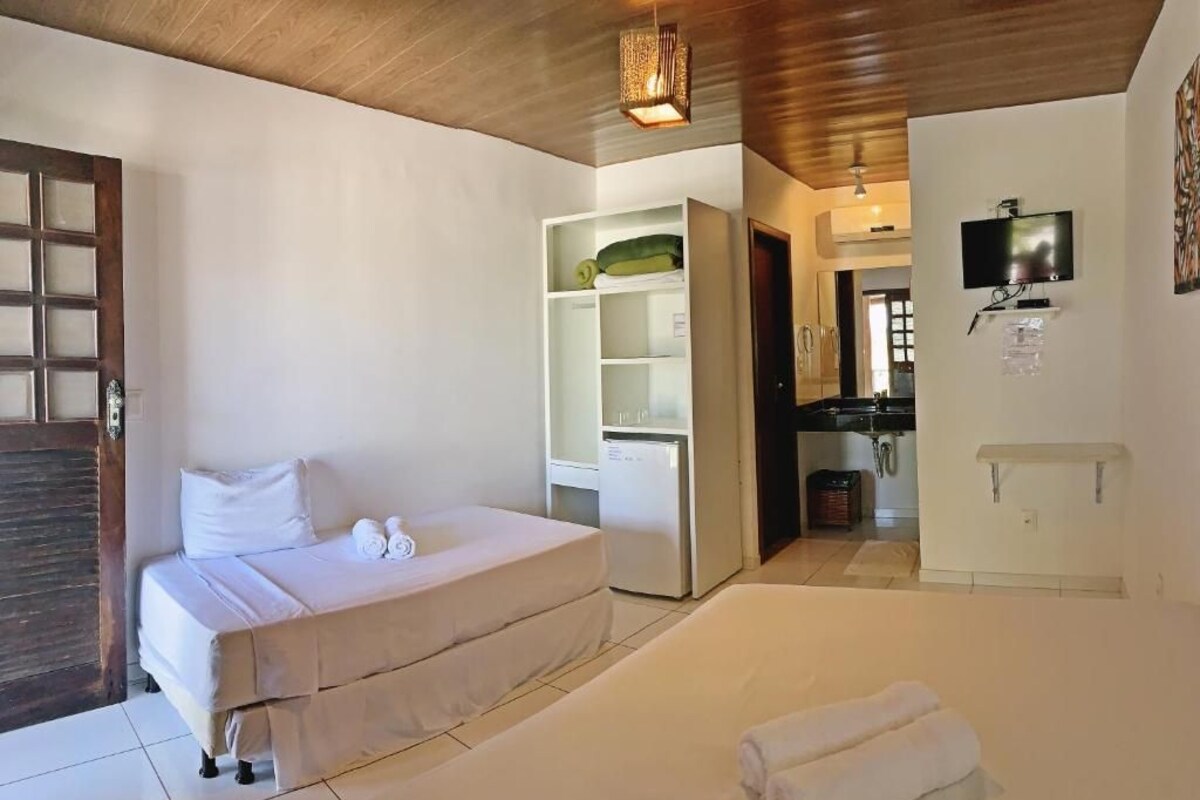Een slaapkamer met een bed, een kledingkast, een televisie en een badkamer.