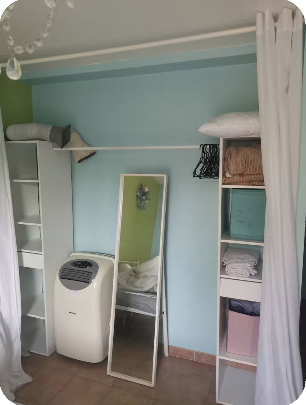 Una stanza con un letto a castello, un termosifone, uno specchio e un armadio.