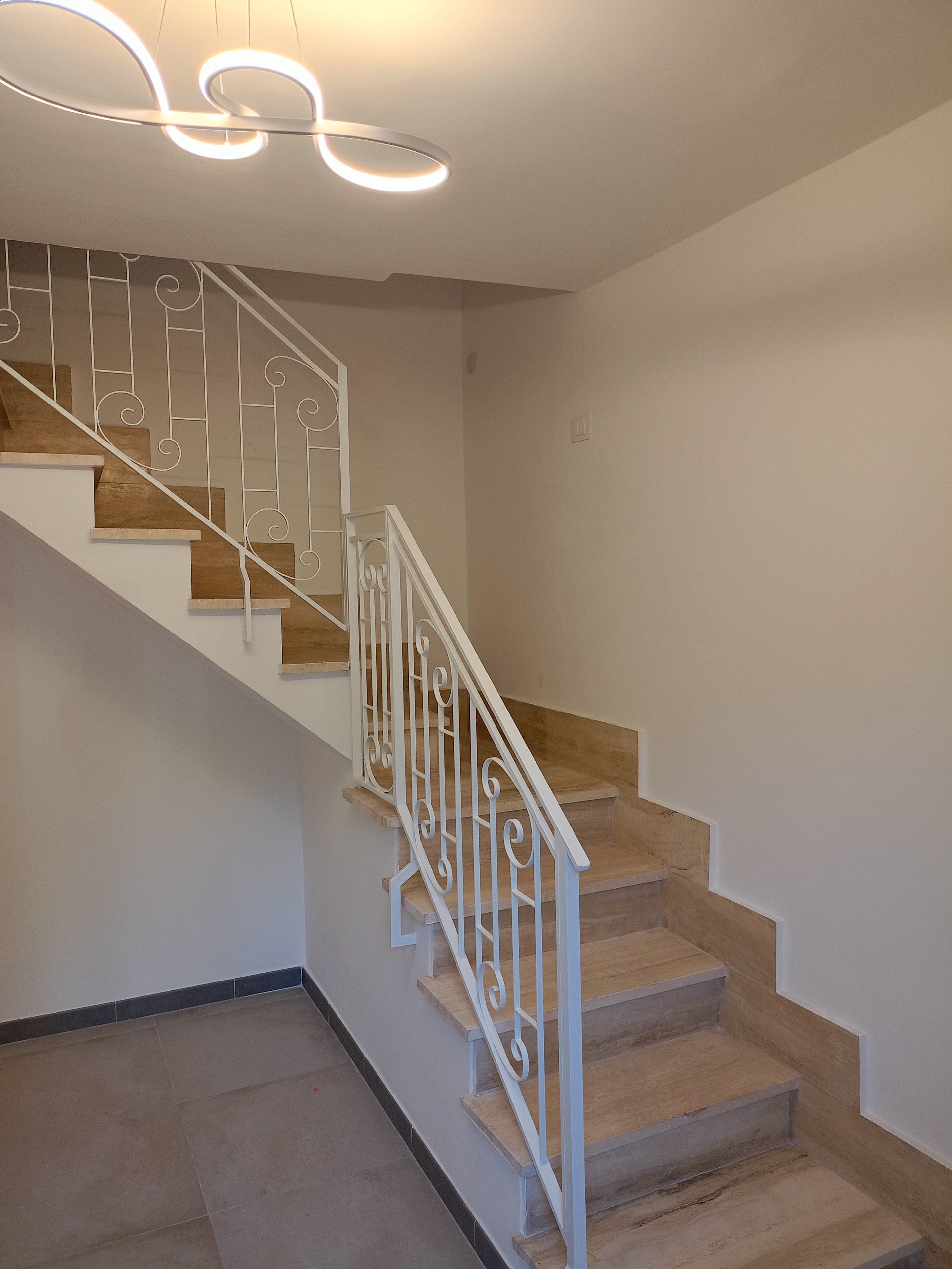 Un escalier avec des rampes blanches et des marches en bois.