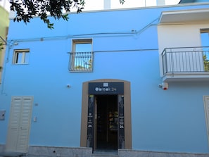 Un edificio con fachada azul, un cartel que dice 'Obreac 24 contemporary break' y una entrada visible.