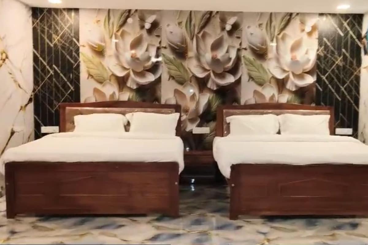 A double bed room with a marble floor and a floral wallpaper design.