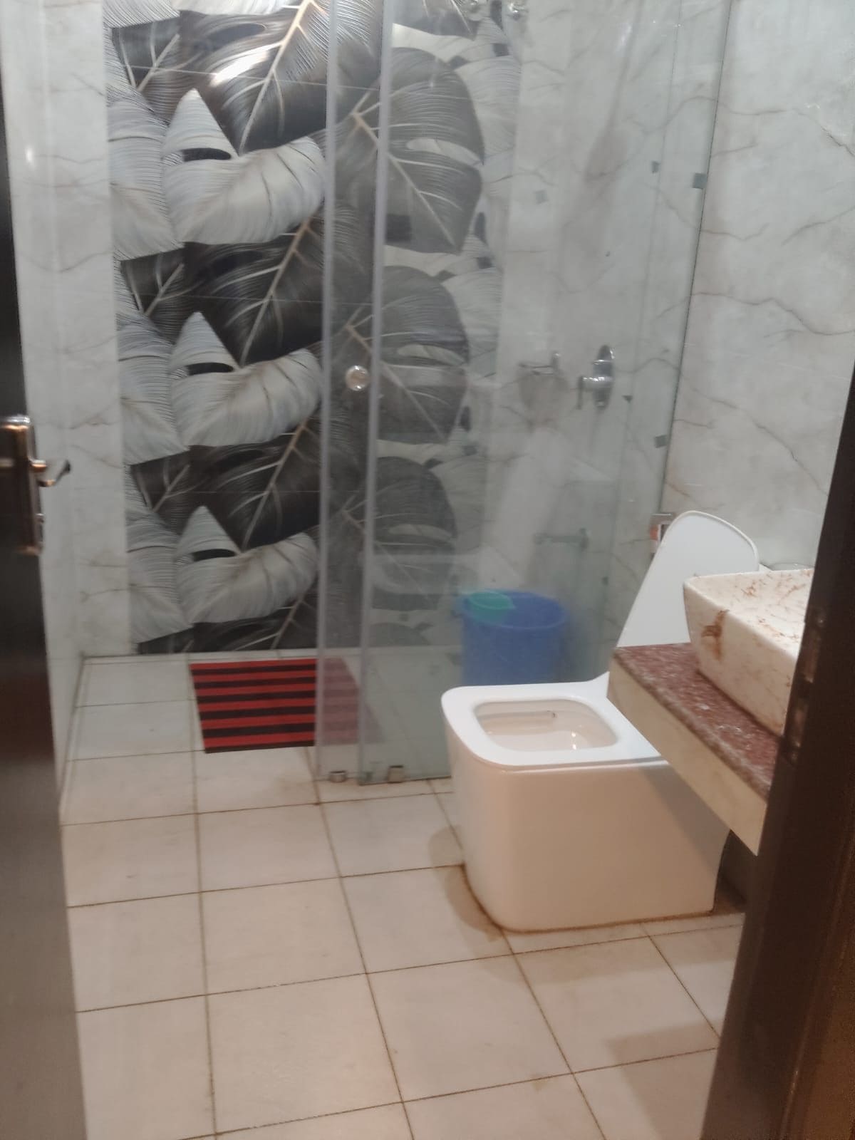 Un baño con cabina de ducha de vidrio, inodoro y zona de lavamanos.