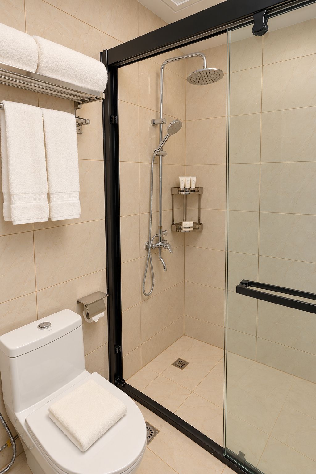 Une salle de bain moderne avec une douche à parois de verre, des toilettes sur lesquelles est posée une serviette, et une étagère contenant des articles de toilette.