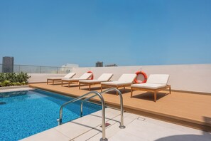 A rooftop pool area with lounge chairs and a swimming pool. - StayShort - Elegant 1 Bedroom in JVC that Sleeps 2 (JVC)