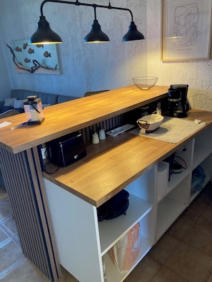 Ein Küchenbereich mit einer Holzausstattung, einer Kaffeemaschine und einem Wasserkocher.