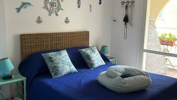 Una camera da letto con un letto, una ventola a soffitto e decorazioni a tema nautico.