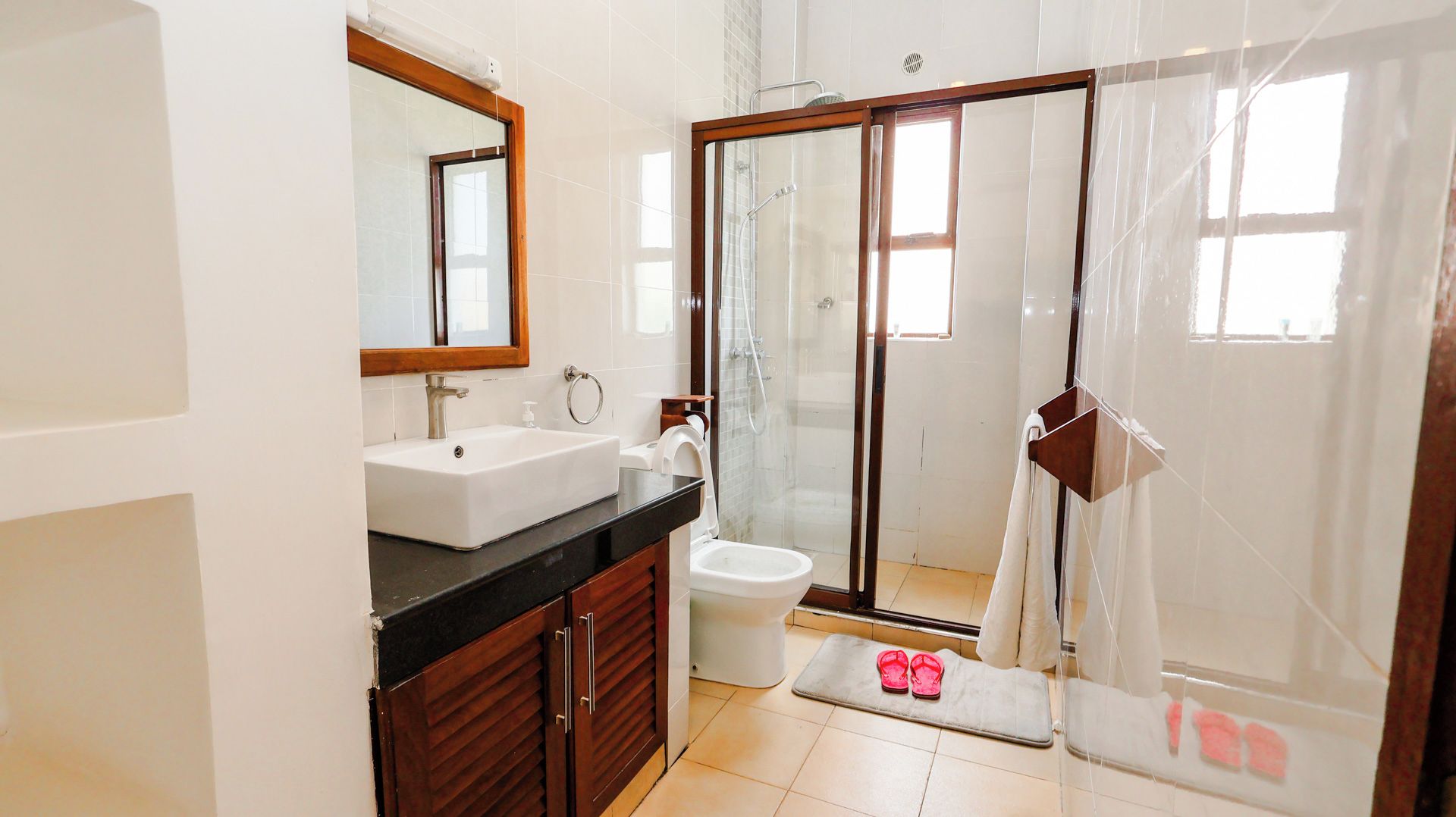 A bathroom with a sink, toilet, and shower area.