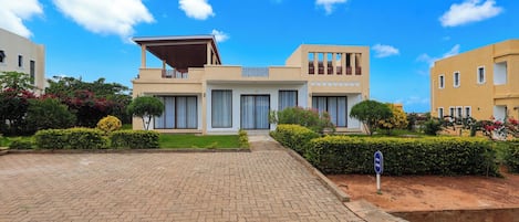 A modern two-story house with a paved driveway and a well-maintained garden.