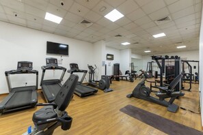 A gym with treadmills, elliptical machines, and weightlifting equipment. - New York industrial style JVC (Dubai)