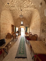 A room with stone walls, wooden tables, and chairs arranged for dining.