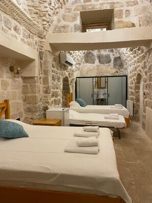 A stone-walled room with two beds, a wooden chair, a small table, and a mirror. - ASEL KONAK (Mardin)