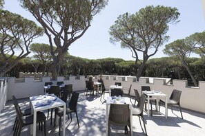 An outdoor dining area with tables and chairs, surrounded by trees. - Continental Camping Village  (Marina di Castagneto Carducci)
