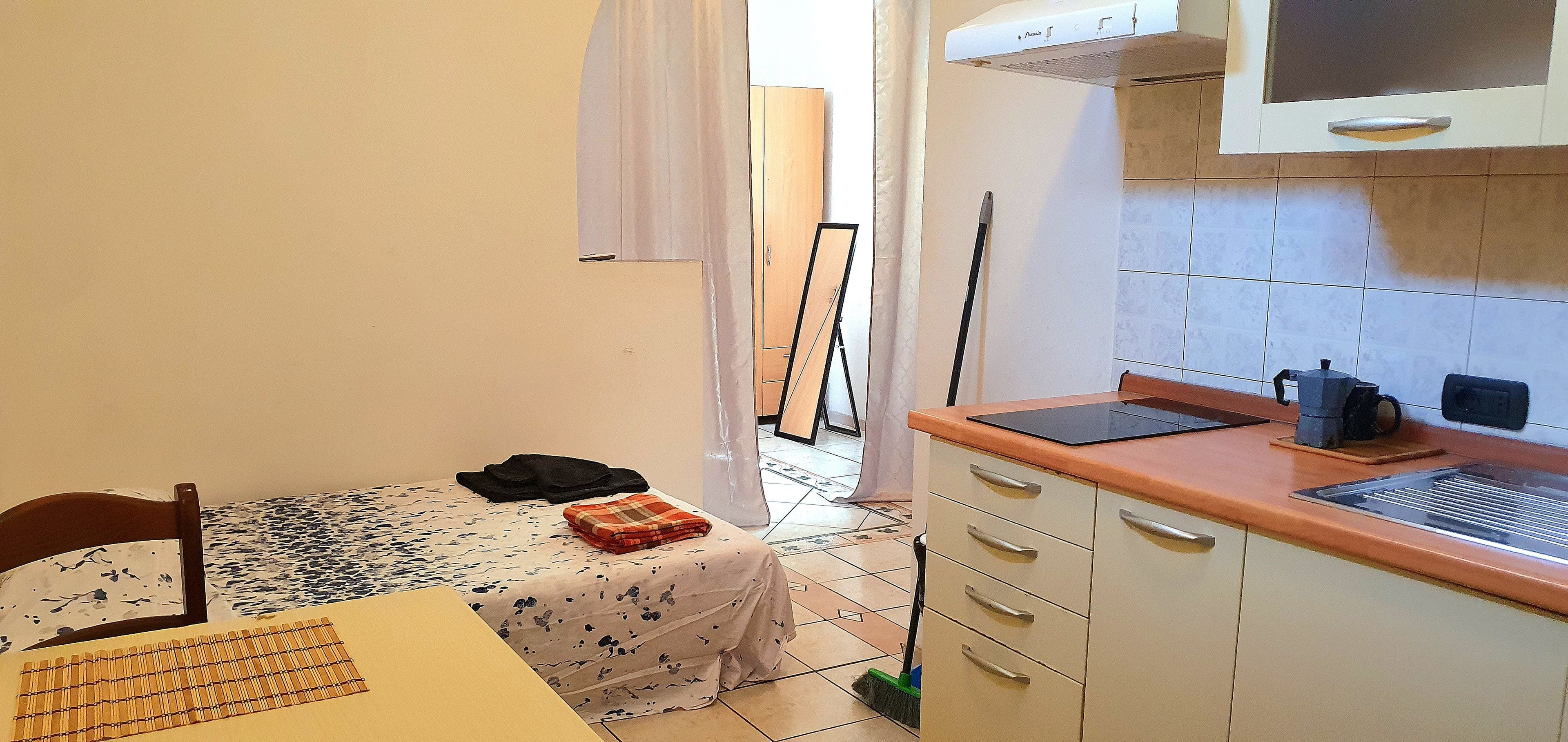 A compact kitchen with a dining table, a microwave, and a sink.